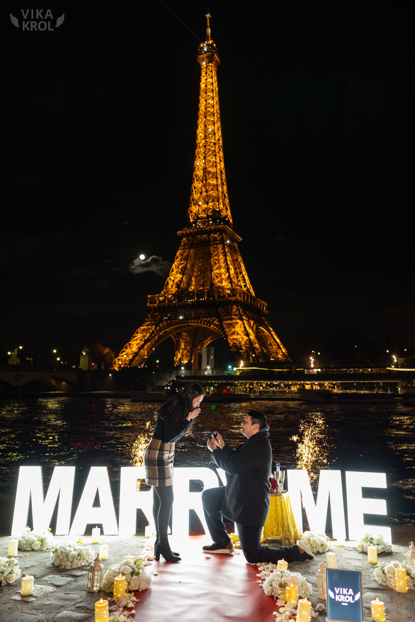 A stunning, emotional photo of a woman's face at the exact moment she opens her eyes to see the proposal scene, tears of joy visible, with the sparkling Eiffel Tower in the background.