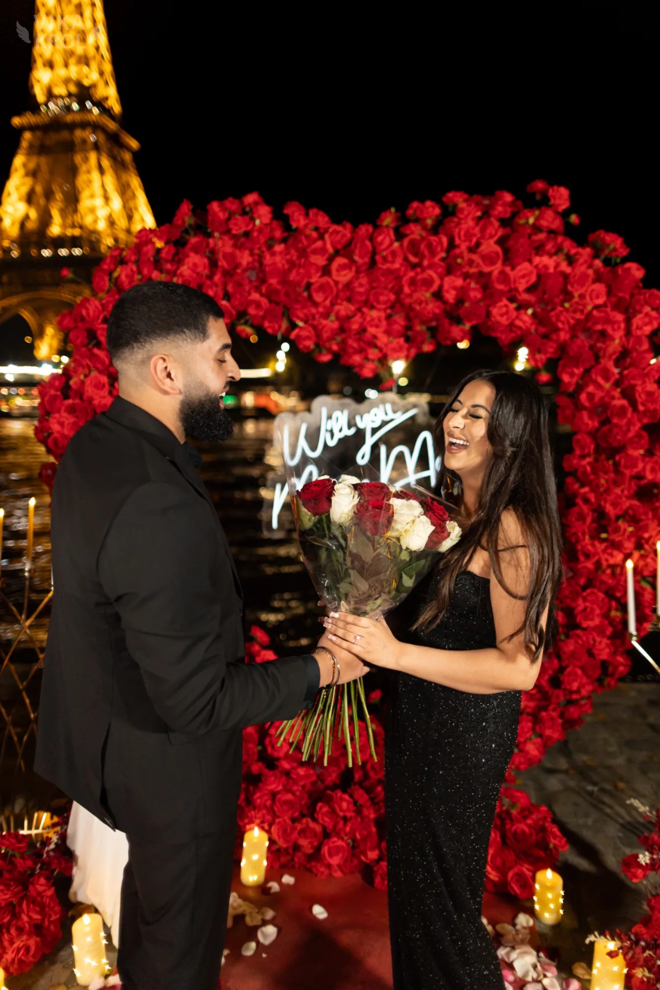 A behind-the-scenes shot of the Vika Krol team setting up candles and lanterns, with the Eiffel Tower blurry in the background before sunset. A behind-the-scenes shot of the Vika Krol team setting up candles and lanterns, with the Eiffel Tower blurry in the background before sunset.