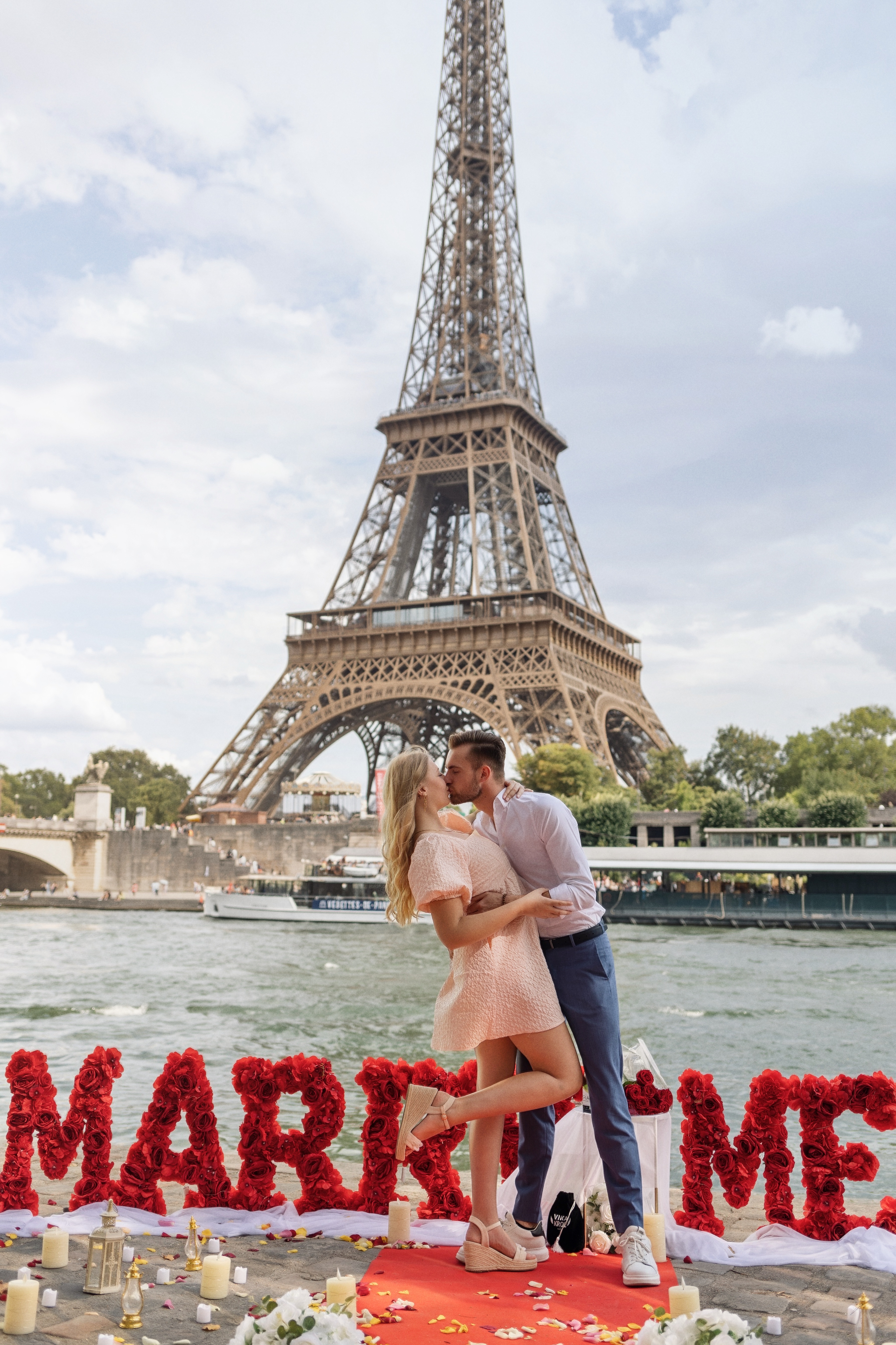 A wide-angle shot of the Pont de Bir-Hakeim at 3:30 PM, showing empty steel arches and a couple standing alone in the center, framed by the Eiffel Tower under a soft grey sky.